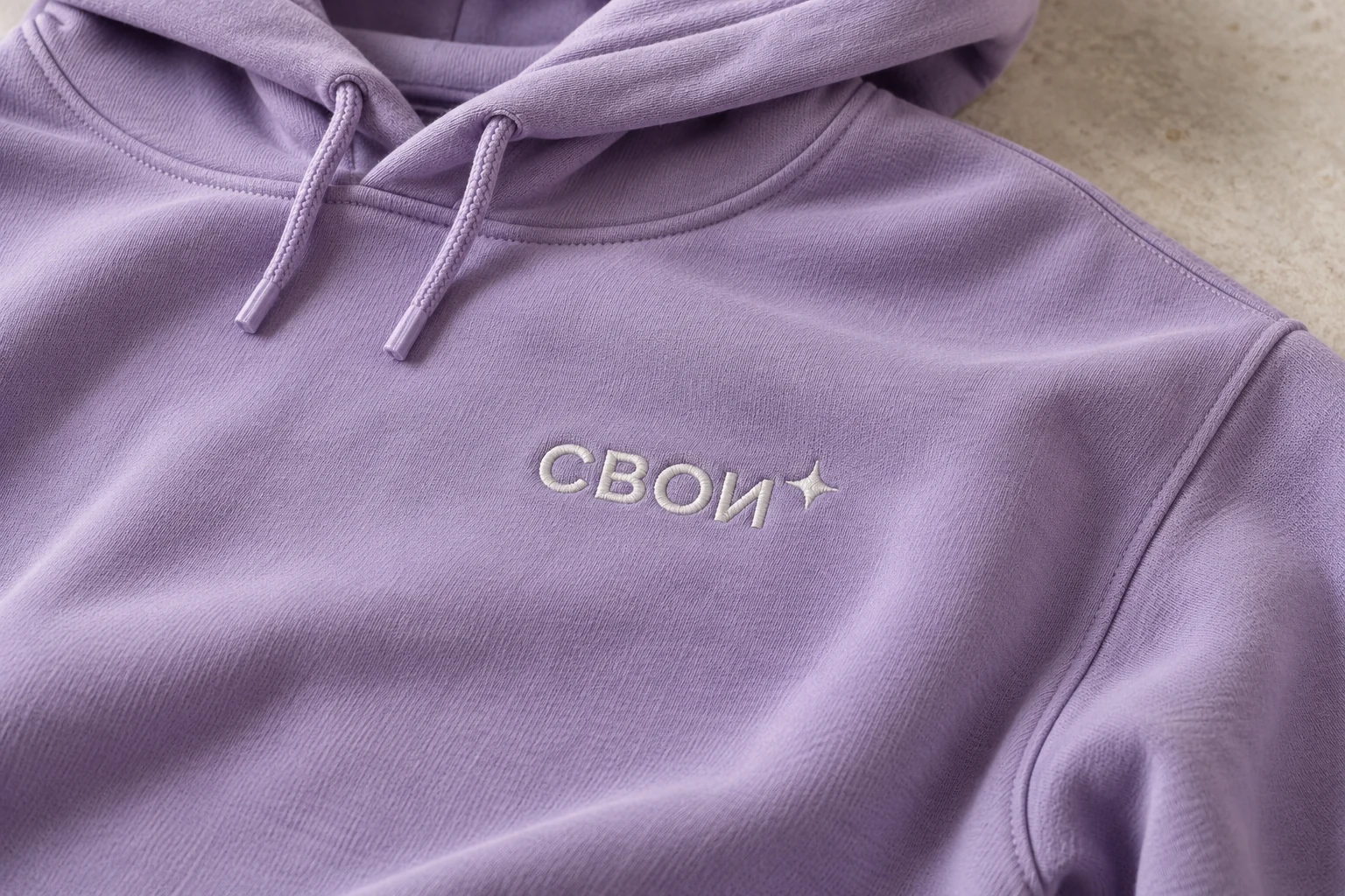 Светлые нитяные стежки вышивки СВОИ на сиреневом худи